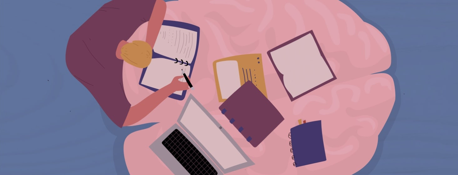 a person with their books and laptop computer spread out on a brain-shaped table